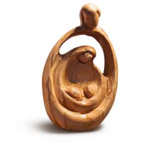 Primo piano di una mano che sorregge una Natività stilizzata in legno d'olivo di Betlemme dalle venature calde. Sullo sfondo, un cartello dell'associazione "La Grotta APS" spiega l'impegno sociale e il sostegno agli artigiani della Palestina.